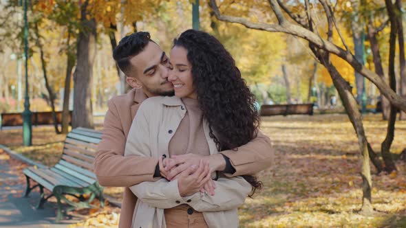 Hispanic Family Hugging Standing in Autumn Park Young Couple Smiling Talking Romantic Date Outdoors