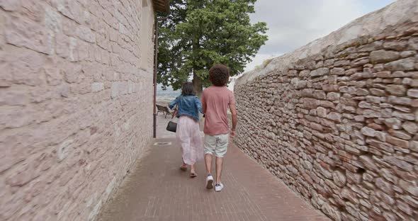 Romantic Couple Walking Visiting Happy Rural Town of Assisi.Back follow.Friends Italian Trip in