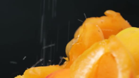 Apricot Slices are Sprinkled with Sugar on a Black Background