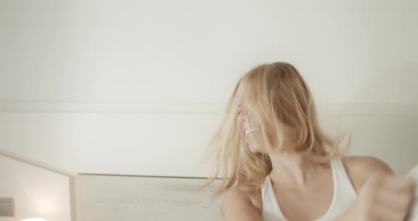 Woman Playing Pillow Fight in Broad Daylight