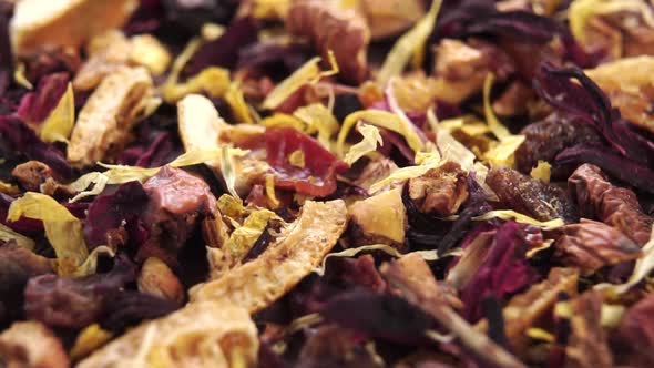 Organic herbal fruit flower tea on a wooden surface. Falling dry herbs, petals and pieces