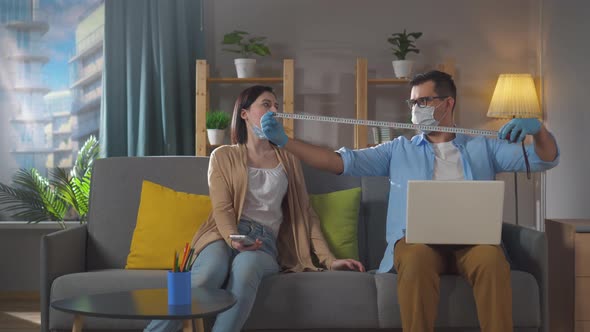 Man and a Woman Keep Their Distance at Home in Quarantine Humor