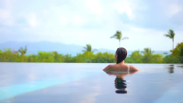 Young asian woman enjoy around outdoor swimming pool for leisure