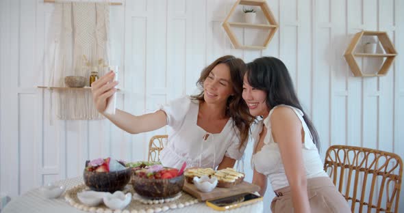 Two Young Woman Meeting at Cafe and Making Selfies Asian and European Female Enjoying Their Lunch