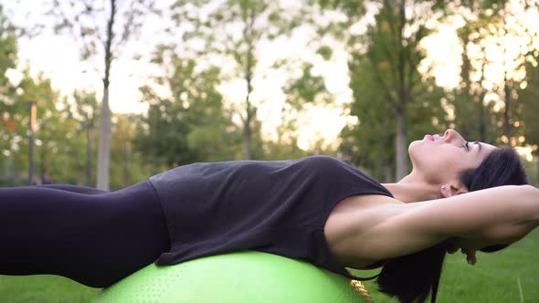 A Woman Trains Her Abdominal Muscles Using a Fitness Ball