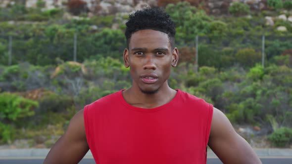 Portrait of african american man exercising outdoors looking at camera on a coastal road