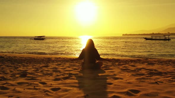 Single female sunbathing on paradise coast beach adventure by shallow ocean with white sand backgrou