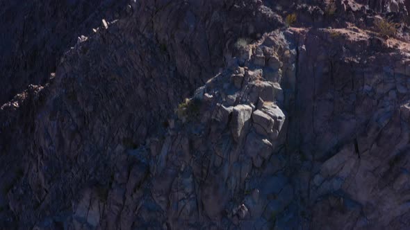 Epic scene of the Flag of the United States of America sits proudly and tall above a rocky mountain