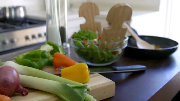 Bowl of salad and fresh vegetables kept on kitchen worktop