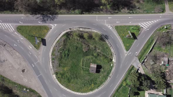 Roundabout traffic of cars and trucks on the circle ring road aerial top view.