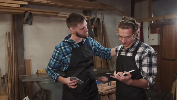 Two Carpenters Talking in Their Workshop