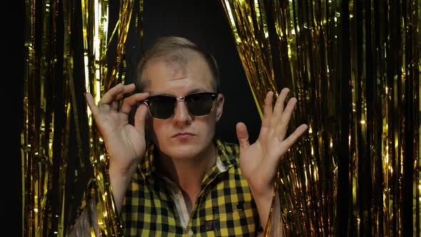 Portrait of Caucasian Man Posing on Black Background. Gold Shining Foil Strips. Party, Music, Disco