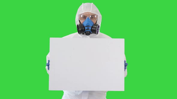 Lab Scientist in Safety Suit Holding Empty White Board on a Green Screen, Chroma Key