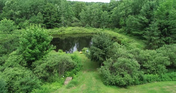 Drone flies over the windblown tree tops to reveal a private fishing spot in the Catskill Mountains.