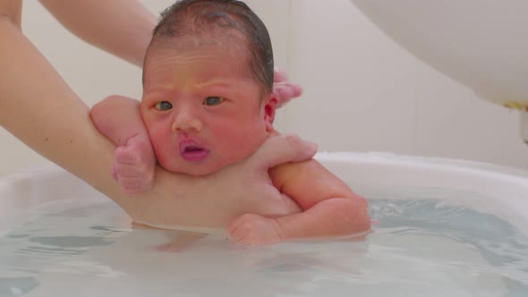 Calm of asian newborn baby bathing in bathtub