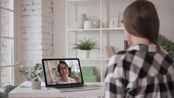 Young Woman Having Video Chat Through Laptop Webcam Talking To Mom