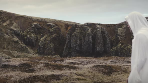 Person Wearing A White Robe Walks Into The Frame Of Mountain