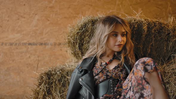 Sensual Woman Resting on Hay in Barn