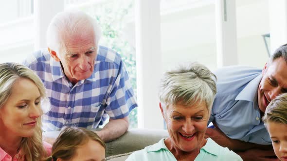 Multi-generation family sitting together in living room