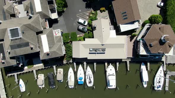 AERIAL DIRECTLY ABOVE Moored Yachts Anchored In Front Of Riverside Homes