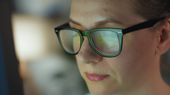 Woman in Glasses Looking on the Monitor and and Working with Charts and Analytics