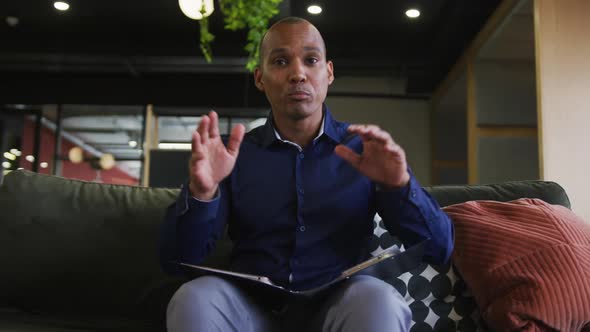 Mixed race businessman having video chat talking and gesturing in office