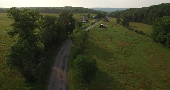 Aerial views of family bicycling along pastoral country roads.