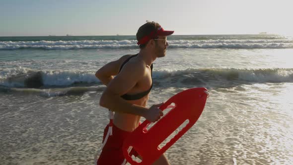 Male lifeguard running along the beach