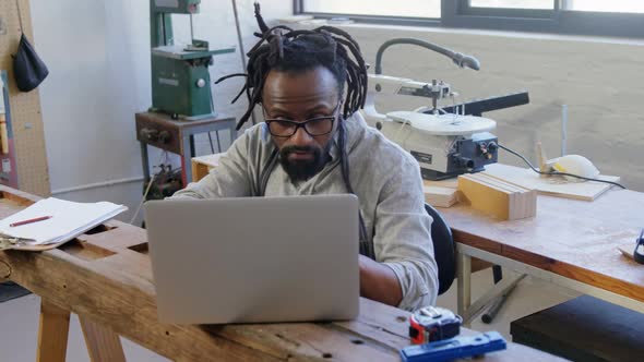 Carpenter using laptop at table 4k