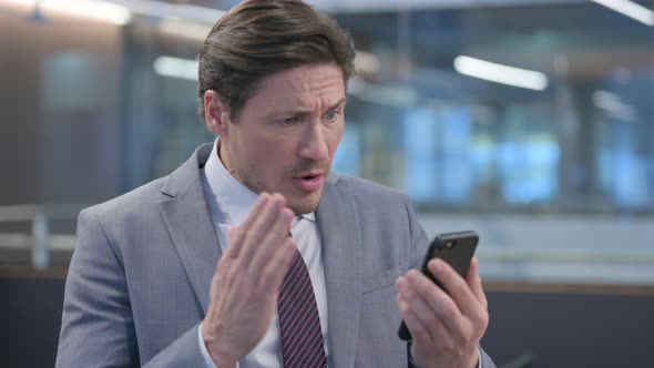 Portrait of Middle Aged Businessman Loss on Smartphone