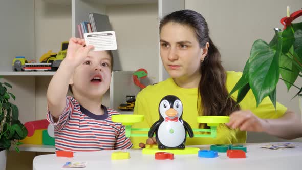 Mom and Son Play with Numbers Weigh a Penguin on a Toy Scale