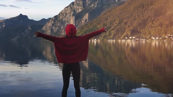 Travel Adventure Lifestyle. Woman Raise Hands Up in Front of Alpen Mountains at Sunset. Picturesque