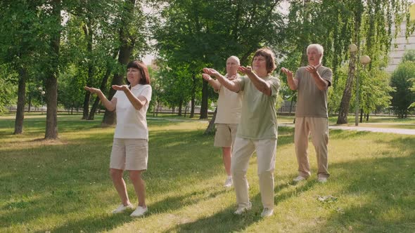 Group of Four Active People Exercising in Park