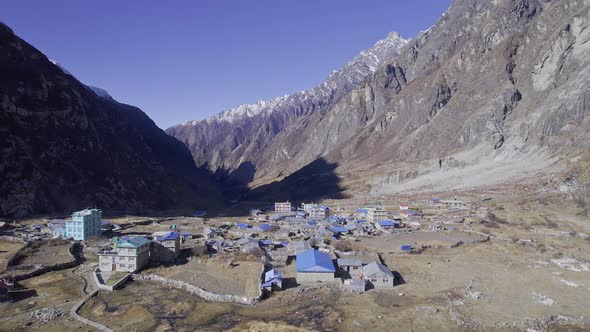 Flying over village with blue roofs in Langtang Nepal, in the mountains