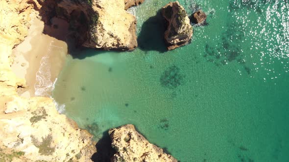 Idyllic clear Emerald green mediterranean sea on Lagos coast, Algarve - Aerial top view