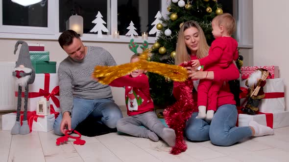 Happy Family Having Fun and Playing Together Near Christmas Tree Children Kiss