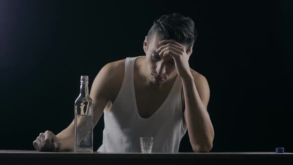 Depressed Man Drinking Vodka in a Dark Room