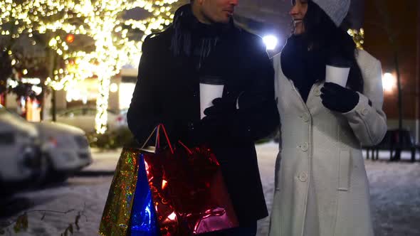 Couple interacting while having coffee at night