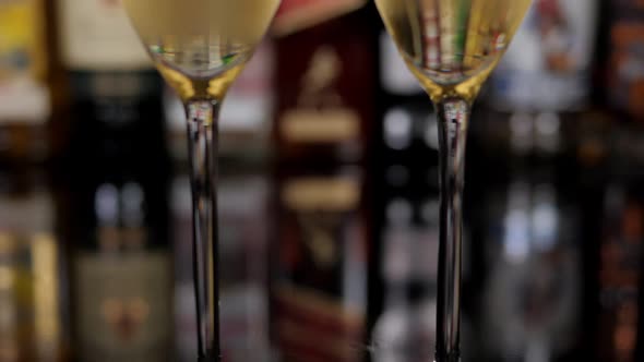 Closeup of Two Misted Glasses of Champagne Against the Background of a Bar