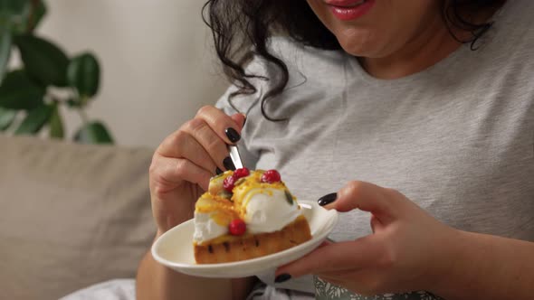 Smiling Young Woman Eating Cake at Home