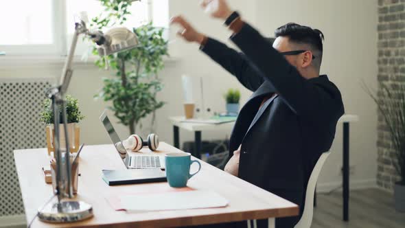 Joyful Guy Using Laptop Then Relaxing Smiling Enjoying Rest in Workplace