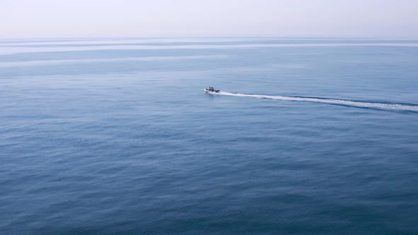 Fishing boat speeding into very  calm mediterranean sea