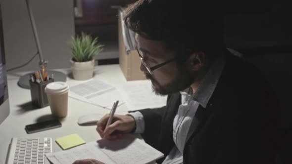 Man Working Hard in Dark Office