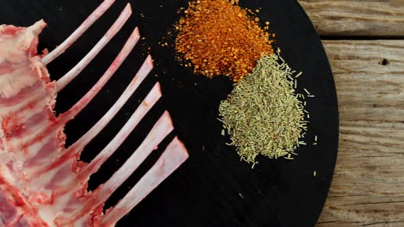 Raw beef ribs and ingredients on wooden board