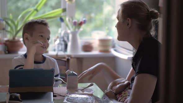 Mum Nursing Baby and Playing Rock-paper-scissors with Son