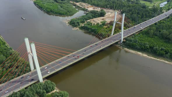 Aerial shooting from flying drone car traffic on modern highway bridge over river