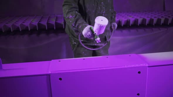 Professional hand spray painting of a metal part in purple color