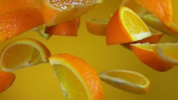 Juicy Delicious Slices of Ripe Orange are Bouncing Up on the Yellow Background