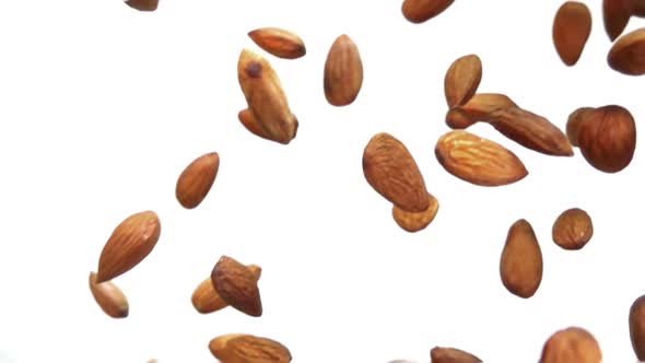 Closeup of Delicious Almonds Falling Diagonally on a White Background