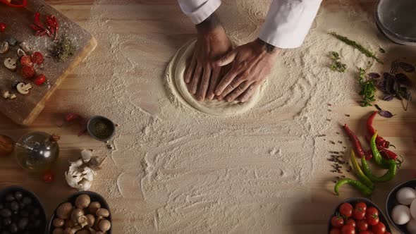 Pastry Cook Hands Kneading Raw Bread Dough on Restaurant Kitchen Cutting Board